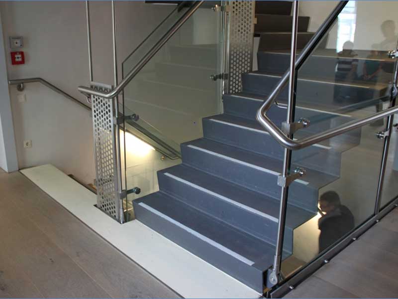 Treppe mit Stufenmarkierung und Handlauf in einem öffentlich zugänglichen Gebäude