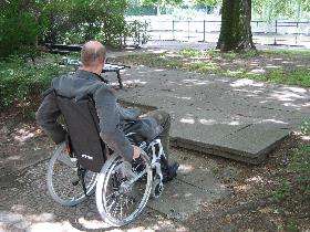 Rollstuhlfahrer vor einer Stufe.