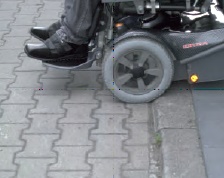 Rollstuhlfahrer an Bordsteinkante