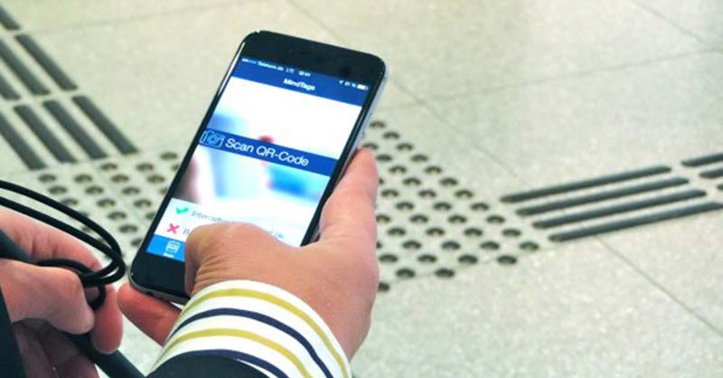 Katastrophenvorsorge für pflegende Angehörige Hand mit Smartphone über einem Bodenleitsystem